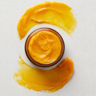 Jar of orange cream with swatches.