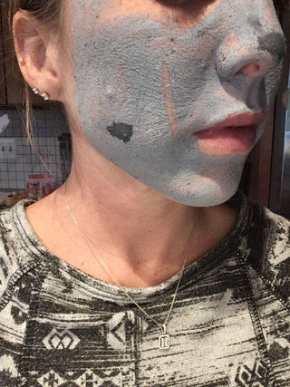 Woman with face mask, skincare routine.