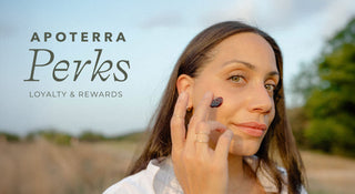Woman applying Hibiscus Mud to her face outdoors with 'Apoterra Perks' text overlay