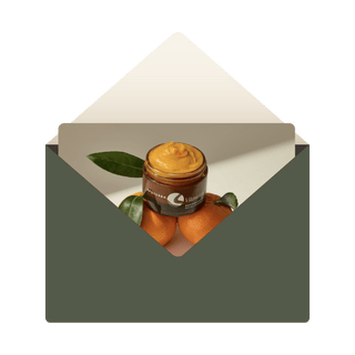 vitamin C balm balanced on oranges inside green envelope