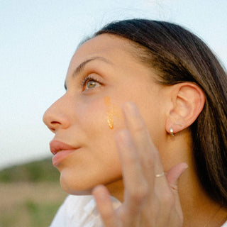 Model Applying Sea Berry Balancing Facial Oil to Face