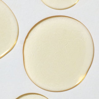 Droplets of the Apoterra neroli mist showcasing its color and watery texture