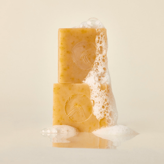 two bars of Apoterra Pumpkin cleanser stacked on top of each other with luscious foamy suds