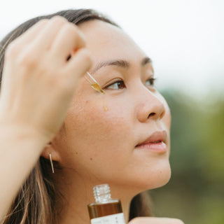 Woman with clear skin applying Apoterra Green Tea Clarifying Facial Oil