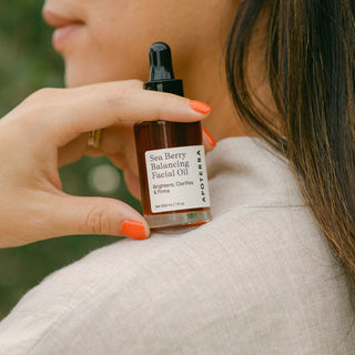 Apoterra Sea Berry Balancing Facial Oil  resting on a women's shoulder