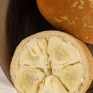 Cupuacu fruit, sliced open, showing inner pulp.