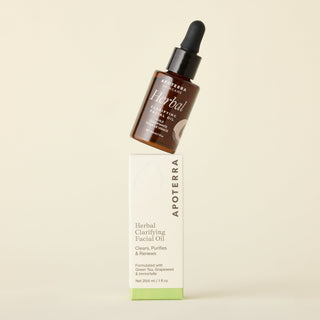 Herbal Clarifying Facial Oil bottle tilted on Apoterra box with clears, purifies, and renews copy.