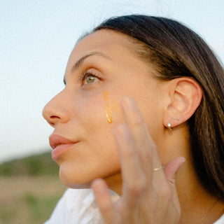 Model applying Apoterra's Sea Berry Balancing Facial Oil for hydration