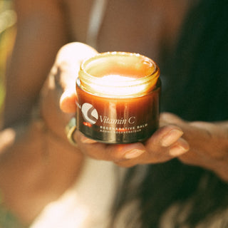 Lifestyle image of woman holding a jar of Vitamin C Regenerative Balm by Apoterra