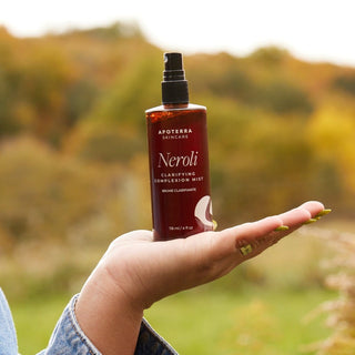Apoterra Neroli Clarifying Complexion Mist being held on model's hand in a lifestyle photo