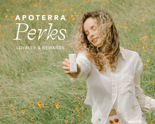 A woman with blonde curly hair in a field of flowers shows an Apoterra facial oil box with text overlaid "Apoterra Perks Loyalty and Rewards"