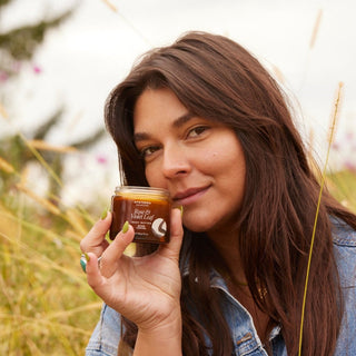 Woman holding a jar of Apoterra Rose & Violet Leaf Body Butter outside