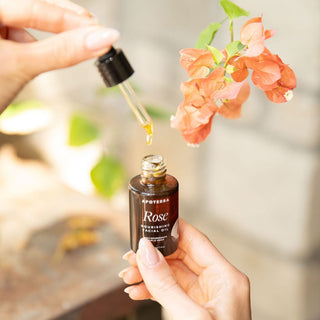 Rose Nourishing Facial Oil by Apoterra bottle and dropper showing rose oil near flowers