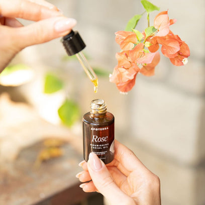 Rose Nourishing Facial Oil by Apoterra bottle and dropper showing rose oil near flowers