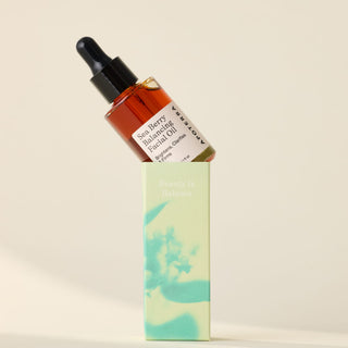 Apoterra Sea Berry Balancing Facial Oil balancing on top of a box with a floral design.
