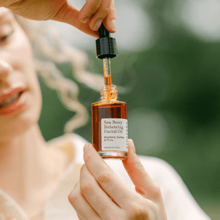 Apoterra Sea Berry Balancing Facial Oil woman holding bottle and dropper lifestyle image 