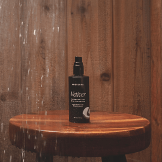 Vetiver Oil Cleanser by Apoterra for breakouts and dry skin support. Lifestyle photo shows Vetiver oil bottle in the shower. 