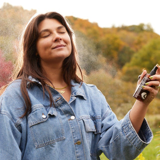 Apoterra Neroli Clarifying Facial Mist being sprayed on woman's face 