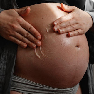Rose & Violet Leaf Body Butter by Apoterra being applied to a pregnant belly for deeply moisturized & nourished skin